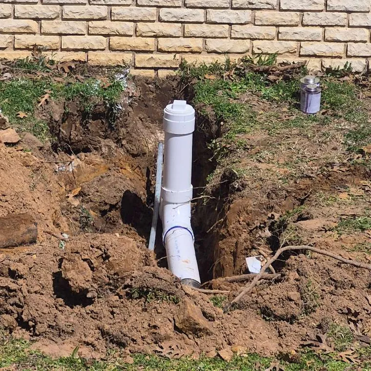 Newly installed PVC sewer cleanout and pipe connection in trench after sewer line repair in Muskogee, Oklahoma
