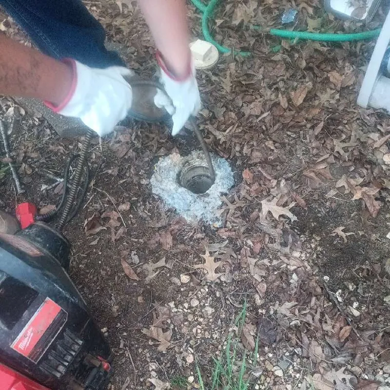 Technician using sewer machine to clear root intrusion from main sewer line in Tahlequah Oklahoma