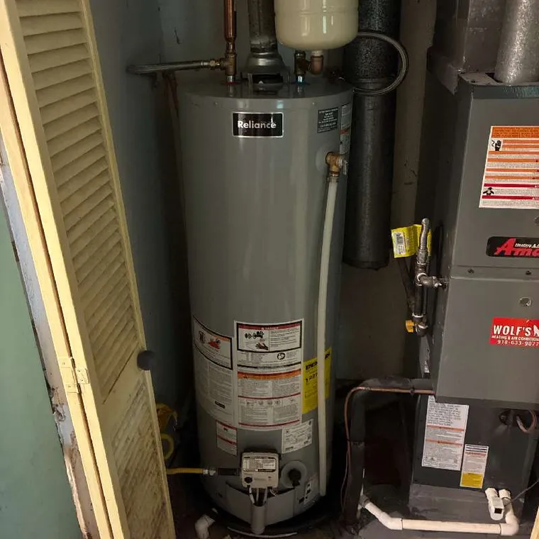 Existing gas water heater before replacement service in Hubert, OK.