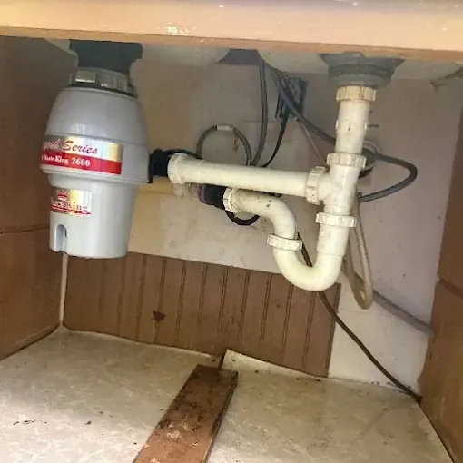 Clog Hunter replacing a garbage disposal under a kitchen sink