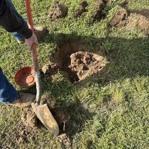 Clog Hunter digging down to a septic tank lid on a rural property