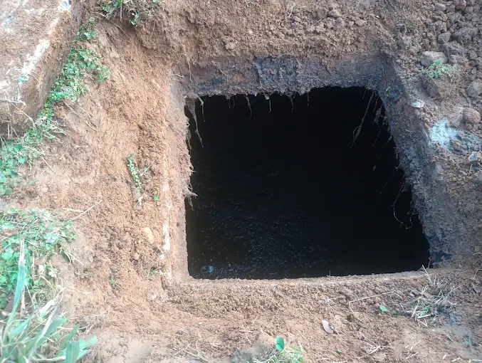 Clog Hunter excavation exposing a septic tank on a rural Eastern Oklahoma property