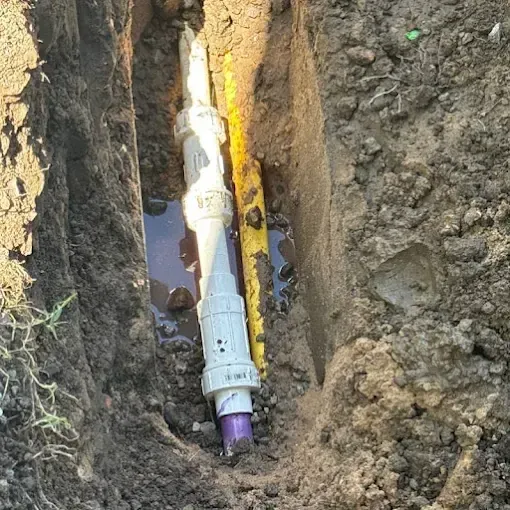 Clog Hunter repairing an underground line in a narrow trench